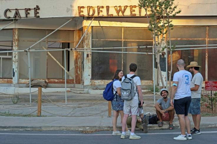 Visitors in front of the dilapidated "Edelweiss" cafe in the fenced-off area of Varosha
