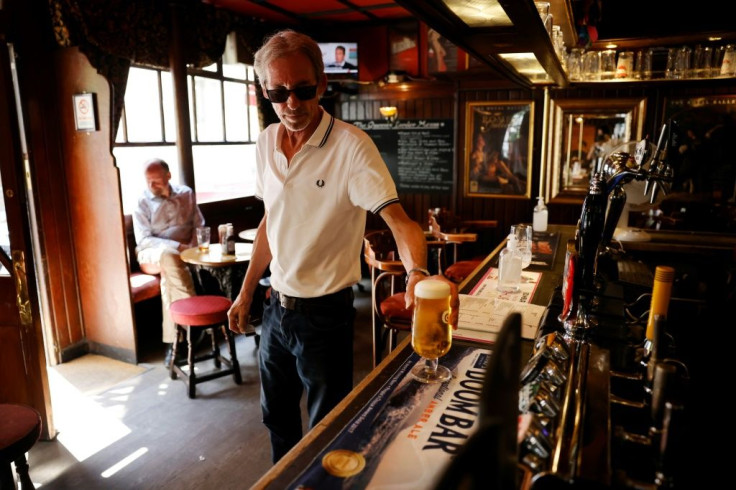 A customer buys a pint in a pub in central London as coronavirus restrictions are lifted.