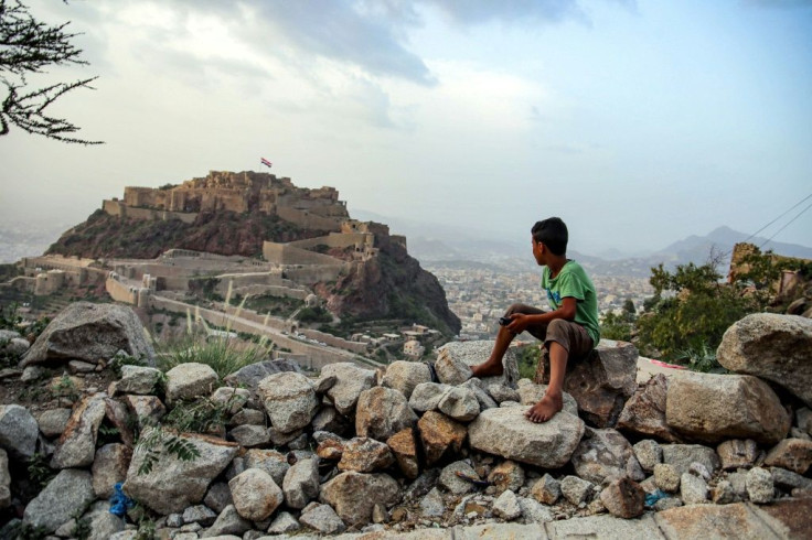 A boy looks at a giant Yemeni flag in the 12th century citadel of al-Qahira in Yemen's third city of Taez, ahead of the Muslim holiday of Eid al-Adha