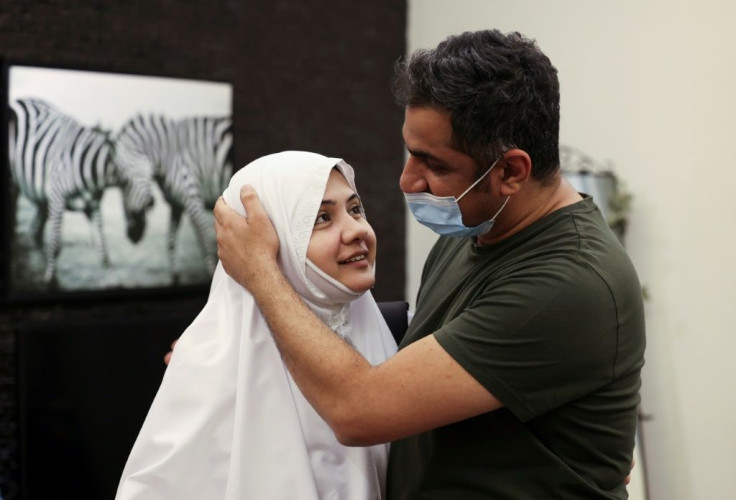 Pakistani pilgrim Bushra Shah bids her husband farewell before leaving for the hajj -- the first time she can do so without a male guardian