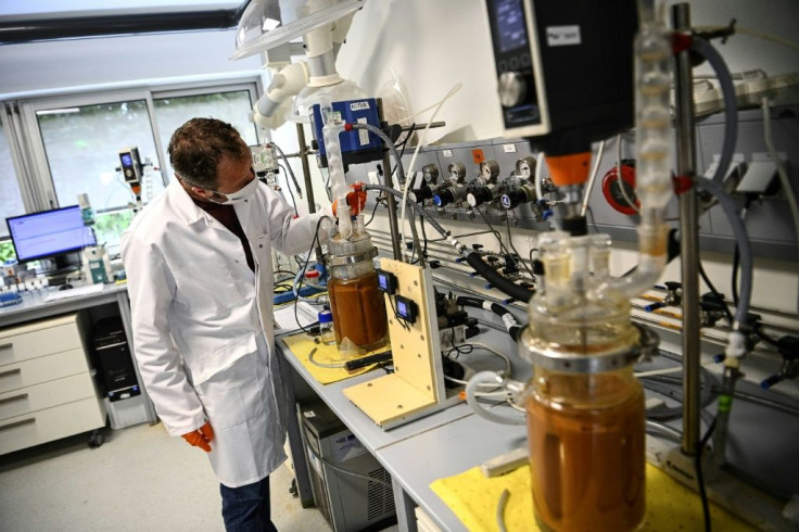Glass jars containing pulverised electronics are injected with bacteria at a lab in western France by engineers aiming to extract rare earth metals