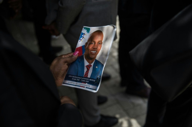 A guest holds a picture of late Haitian president Jovenel Moise during a ceremony in Port-au-Prince