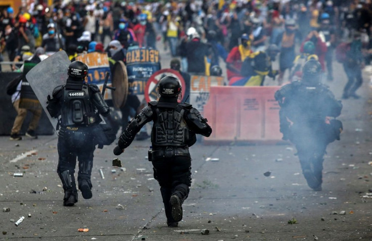 Clashes between riot police and demonstrators, some armed with machetes, left dozens of civilians injured in the cities of Medellin and Cali