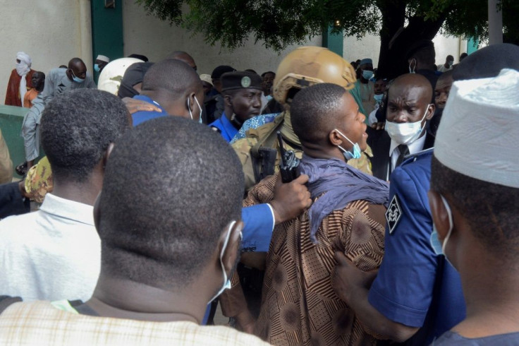 Security personnel escort an alleged attacker from the mosque