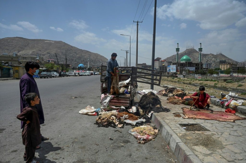 A man unloads cattle skins from a vehicle to be sold at a market area in Kabul on July 21, 2021, as the country marks Eid al-Adha