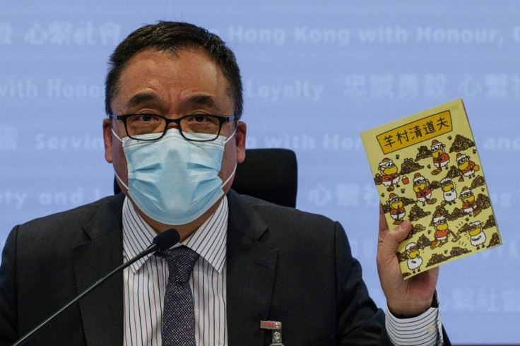 Hong Kong Senior Superintendent Steve Li, from the city's new national security police unit, holds up one of the allegedly seditious children's books