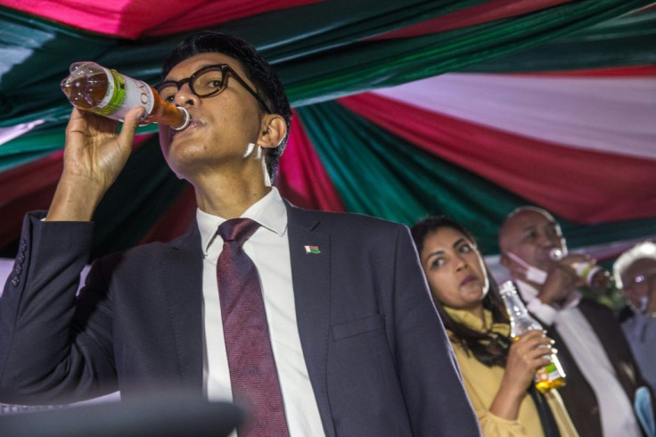 Rajoelina drinks from a bottle of Madagascar's self-proclaimed herbal remedy for coronavirus, Covid-Organics