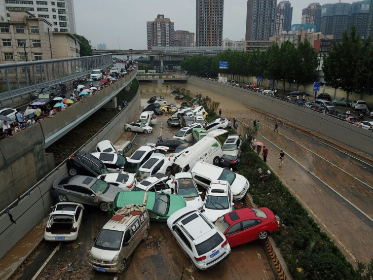 Piles of cars swept away by floods lie at the entrance to a tunnel in Zhengzhou