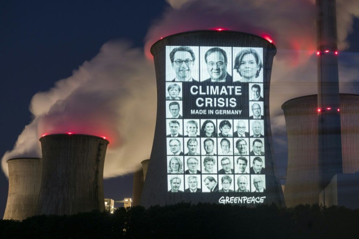 Portraits of 31 politicians are projected with the slogan "Climate crisis, made in Germany" onto a cooling tower of the brown coal power station in in Grevenbroich