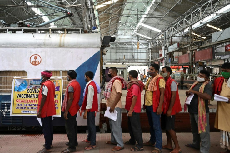 Railway porters wait to get doses of the Covishield vaccine against the Covid-19 coronavirus inside compartments modified as temporary vaccination centers at Sealdah railway station in Kolkata