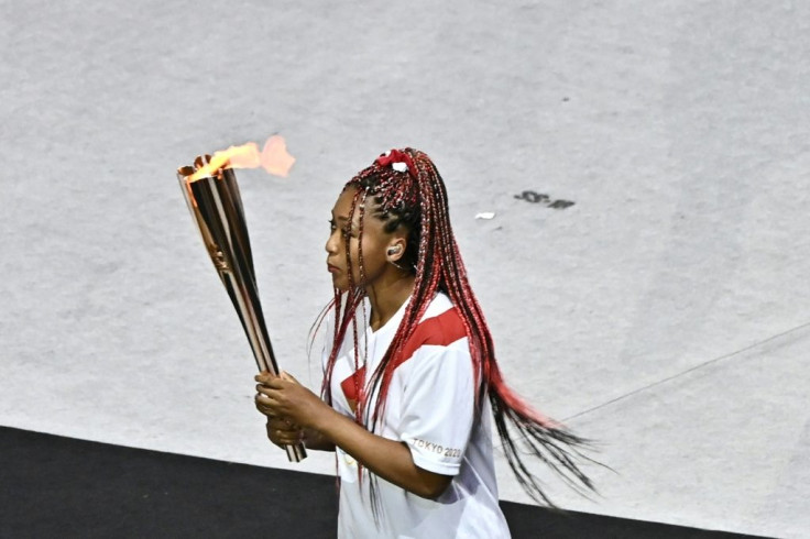 Japanese tennis star Naomi Osaka carries the Olympic torch