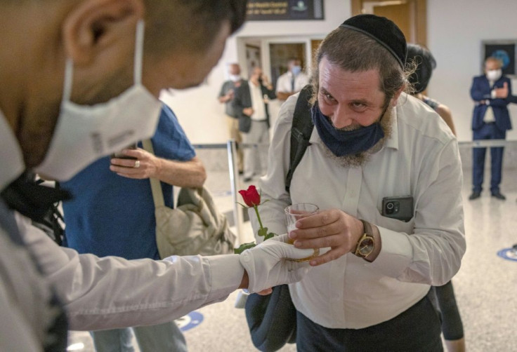 An Israeli tourist is welcomed in Morocco with a rose and a beverage after arriving on the first direct commercial flight between the two countries