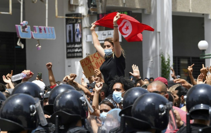 A Tunisian protester waves the national flag at an anti-government rally in front of parliament in Tunis on Sunday