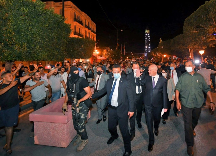 Tunisian President Kais Saied is greeted by supporters late Sunday after he ousted the prime minister and ordered parliament closed