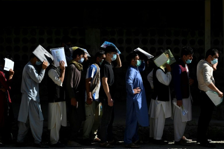 Afghan men line up to apply for a passport in Kabul, with a rush of applications ahead of the final withdrawal of foreign troops from the country