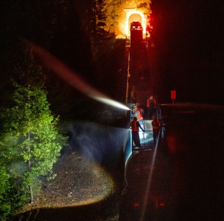 Along steep slopes firefighters have used a train to spray the blaze