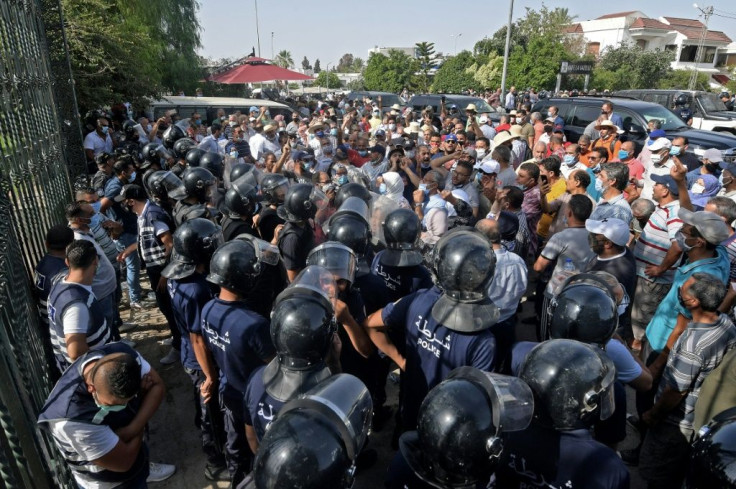 Tunisian security forces hold back protesters outside the parliament building in the capital Tunis on Monday, a day after the president ordered the legislature closed for 30 days