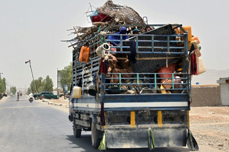 A truck piled with household belongings enters Kandahar as rural residents flee fighting between the Taliban and government forces