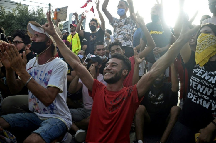 Some Tunisians celebrated the president's move, cheering outside the army-barricaded parliament