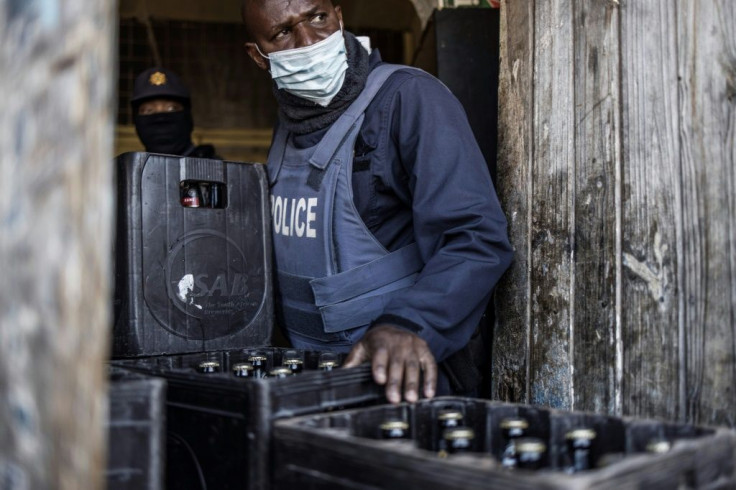 Confiscated: Crates of beer join other suspected stolen goods that police haul away from the hostel