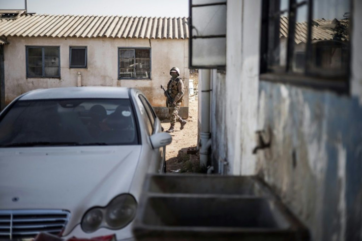 A soldier patrols as police search the hostels