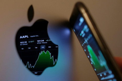 This illustration photo taken on May 24, 2021 shows the Apple stock market ticker symbol AAPL displayed on an iPhone screen and reflected in the logo of an iMac computer