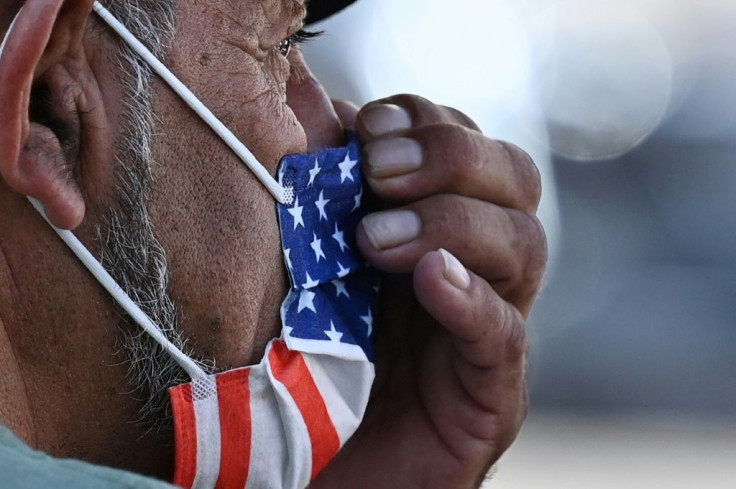 A man adjusts his American flag face mask on a street in Hollywood, California