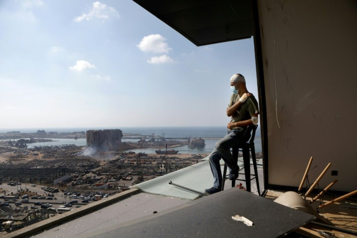 In this file photo taken on August 6, 2020 TV producer Tony Ahwaji sits injured on the balcony of his damaged apartment