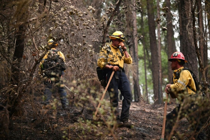 Firefighter hand crews take a break as they put out hot spots and mop up in an area burned in the Dixie Fire
