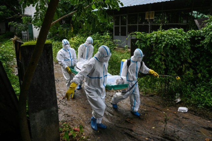 Volunteers carry the body of a Covid-19 victim to a cemetery in Yangon