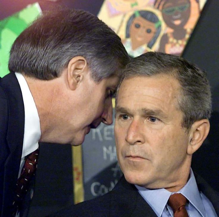 Then US President George W. Bush (R) is informed by his chief of staff Andrew Card about the attacks on the World Trade Center in New York during an early morning event at an elementary school in Florida on September 11, 2001