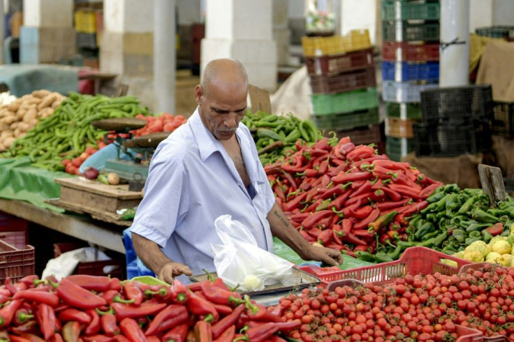 A pedlar weighs produce at a stall at the popular Bab el-Fellah market in Tunisia's capital Tunis
