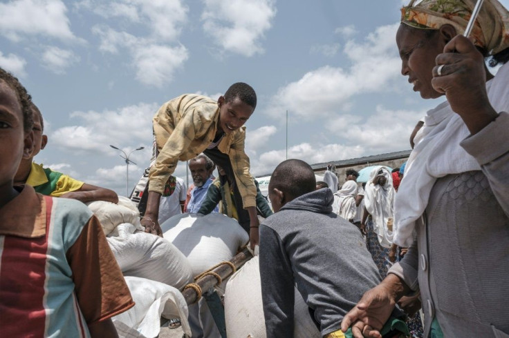 A young person arranges a sack of wheat on a cart during food distribution organized by the Amhara government near the village of Baker, 50 kilometers southeast of Humera, in the Tigray region of Ethiopia, on July 11, 2021.