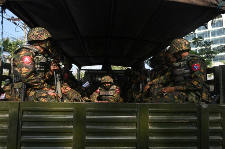 Soldiers sit in an army truck in Yangon