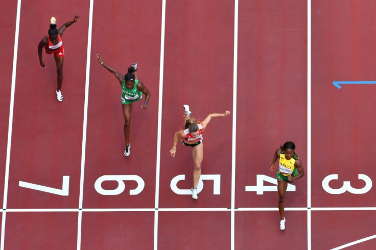 An overview shows Jamaica's Shelly-Ann Fraser-Pryce (R) crossing the finish line to win ahead of second-placed Switzerland's Ajla Del Ponte (2R), third-placed Nigeria's Nzubechi Grace Nwokocha (2L) and Gambia's Gina Bass in the women's 100m heats