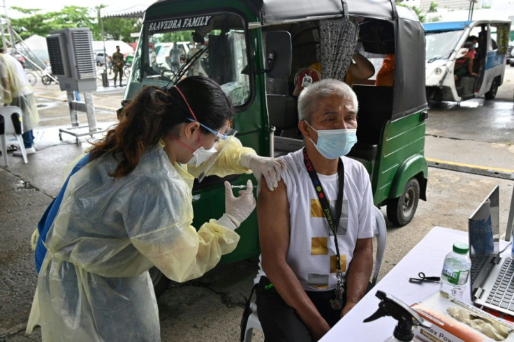 A taxi driver is vaccinated against Covid-19 in Manila