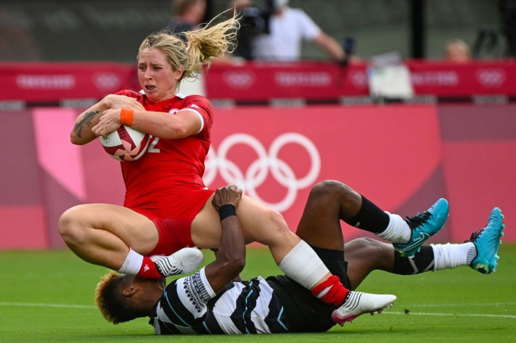 Canada's Kayla Moleschi (left) evades a tackle by Fiji's Roela Radiniyavuni to score a try in the women's pool B rugby sevens match between Canada and Fiji during the Tokyo 2020 Olympic Games.