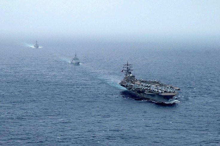A handout photo courtesy of the US Navy's Twitter account on July 25, 2021 shows aircraft carrier USS Ronald Reagan, French navy frigate FS Languedoc, and guided-missile destroyer USS Halsey at sail in the Arabian Sea