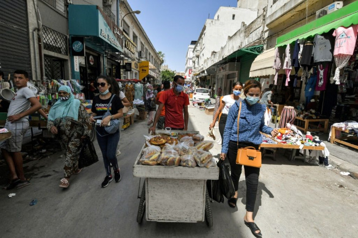 People walk along an alley in Tunisia's capital Tunis on July 28, 2021