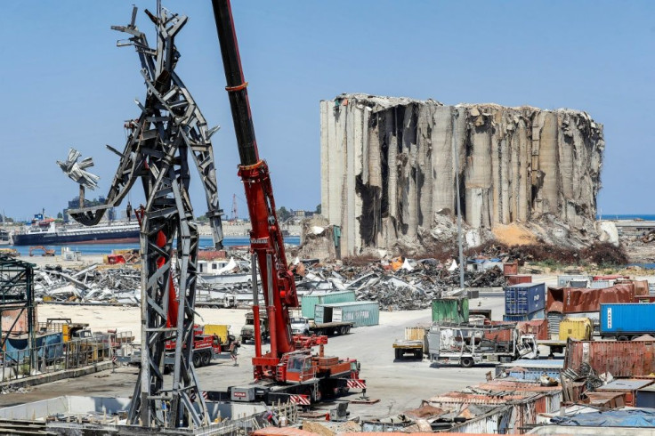 A 25-metre-tall steel sculpture dubbed "The Gesture" made from blast debris hangs from a crane near the devastated grain silos at Beirut port