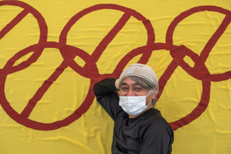 Artist Takatoshi Sakuragawa poses with his anti-Olympic banner