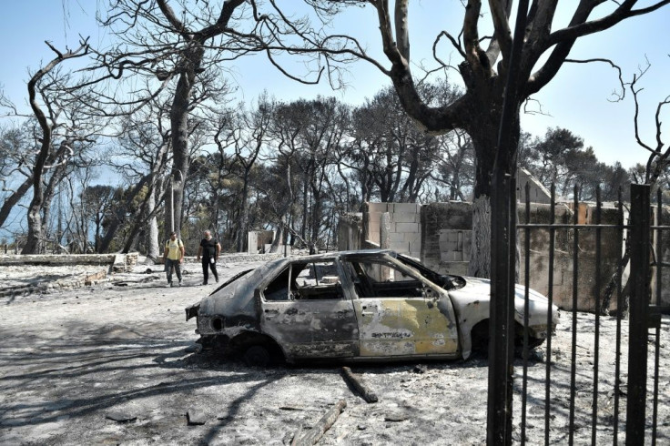 A car destroyed by flames east of Patras in the Peloponnese as Greece battles fires during a punishing heatwave