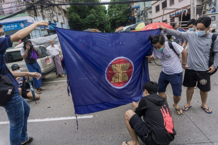 Protesters prepare to burn the ASEAN flag in a June 2021 demonstration in Yangon against the military junta in Myanmar