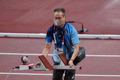 A volunteer sets up a starting block during the athletics at Tokyo 2020