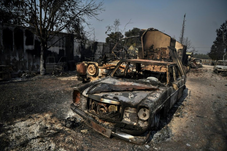 Burnt-out cars after the fire raged through an area at the at the foot of Mount Parnitha, where the fire started
