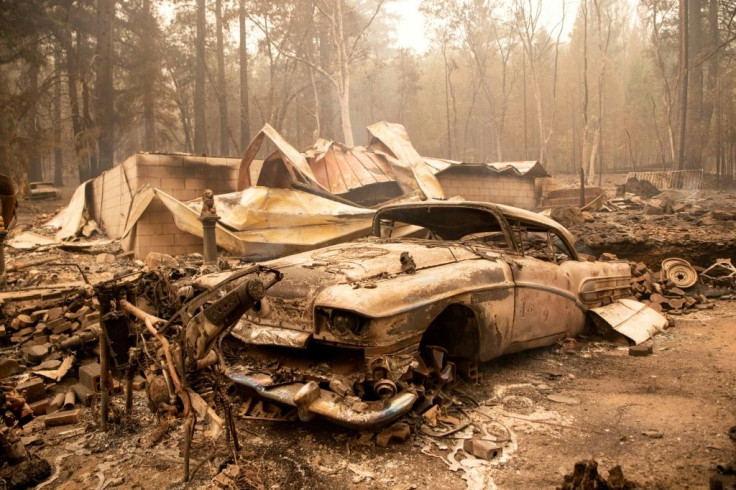 A burned classic car sits among the smoldering remains of a home during the Dixie fire in the Indian Falls neighborhood of unincorporated Plumas County, California on July 26, 2021. The Dixie fire has now burned more than 190,000 acres and continues to ed