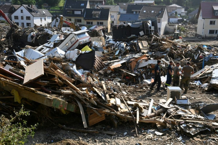 Workers walk amid debris in Kreuzberg, district of Altenahr, Rhineland-Palatinate, western Germany, on July 20, 2021