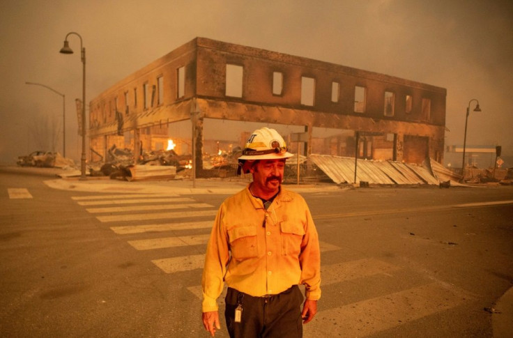 Fire Battalion Chief Sergio Mora looks on as the Dixie Fire burns through downtown Greenville, California