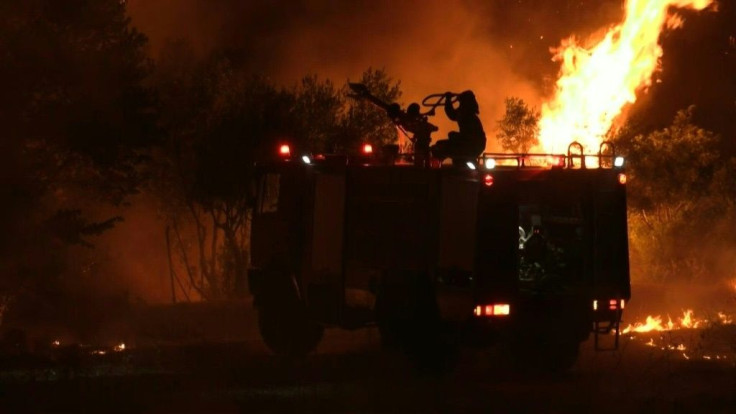 A wildfire rages through the village of Afidnes, north of Athens - a blaze that firefighters had hoped to control but which regained strength after destroying large areas of pine forest