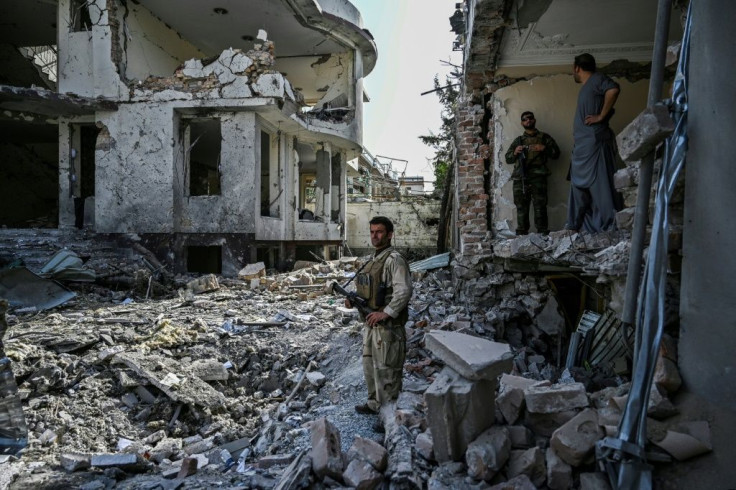 Afghan security personnel on Wednesday inspect the site of a car bomb explosion in Kabul